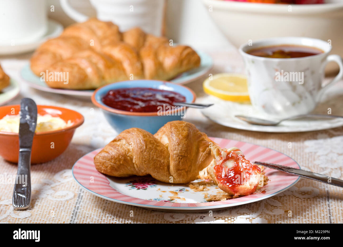 Frisches Croissant mit Marmelade und Butter Stockfoto
