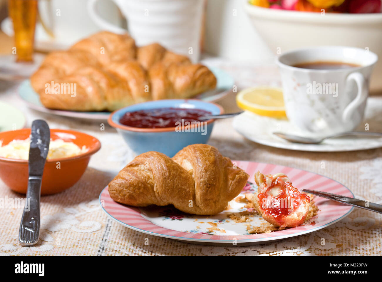 Erdbeer Marmelade und Butter auf frischen Croissants Stockfoto