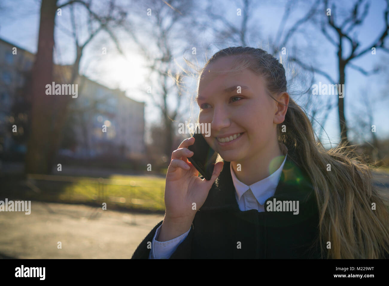 Jugendlich Mädchen zu Fuß in der Stadt und am Telefon zu sprechen im Frühjahr Tag Stockfoto