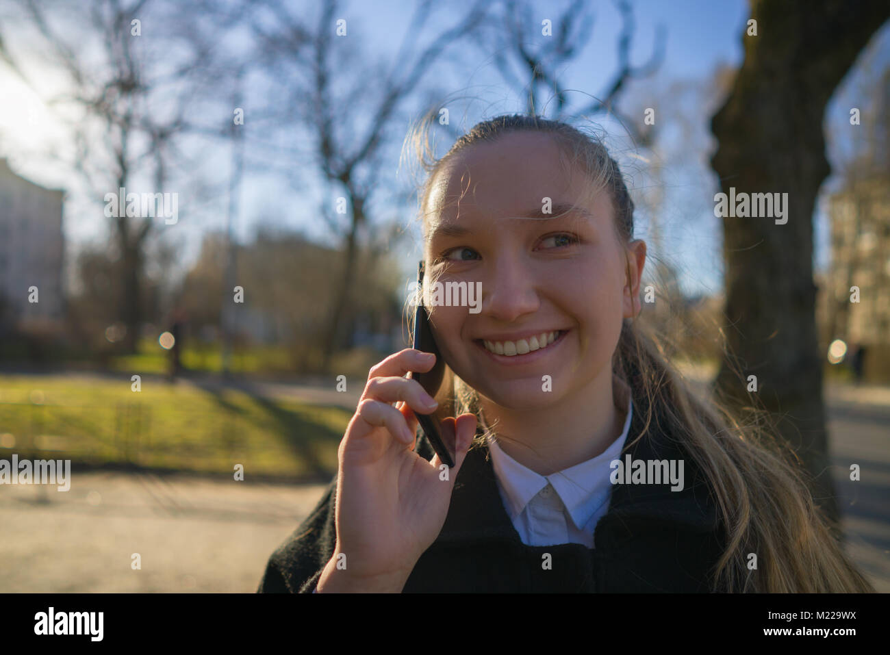 Jugendlich Mädchen zu Fuß in der Stadt und am Telefon zu sprechen im Frühjahr Tag Stockfoto
