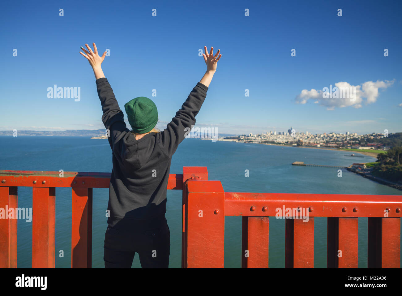 SAN FRANCISCO, USA - ca. November 2017: Teen Girl mit erhobenen Händen auf die Golden Gate Bridge Stockfoto