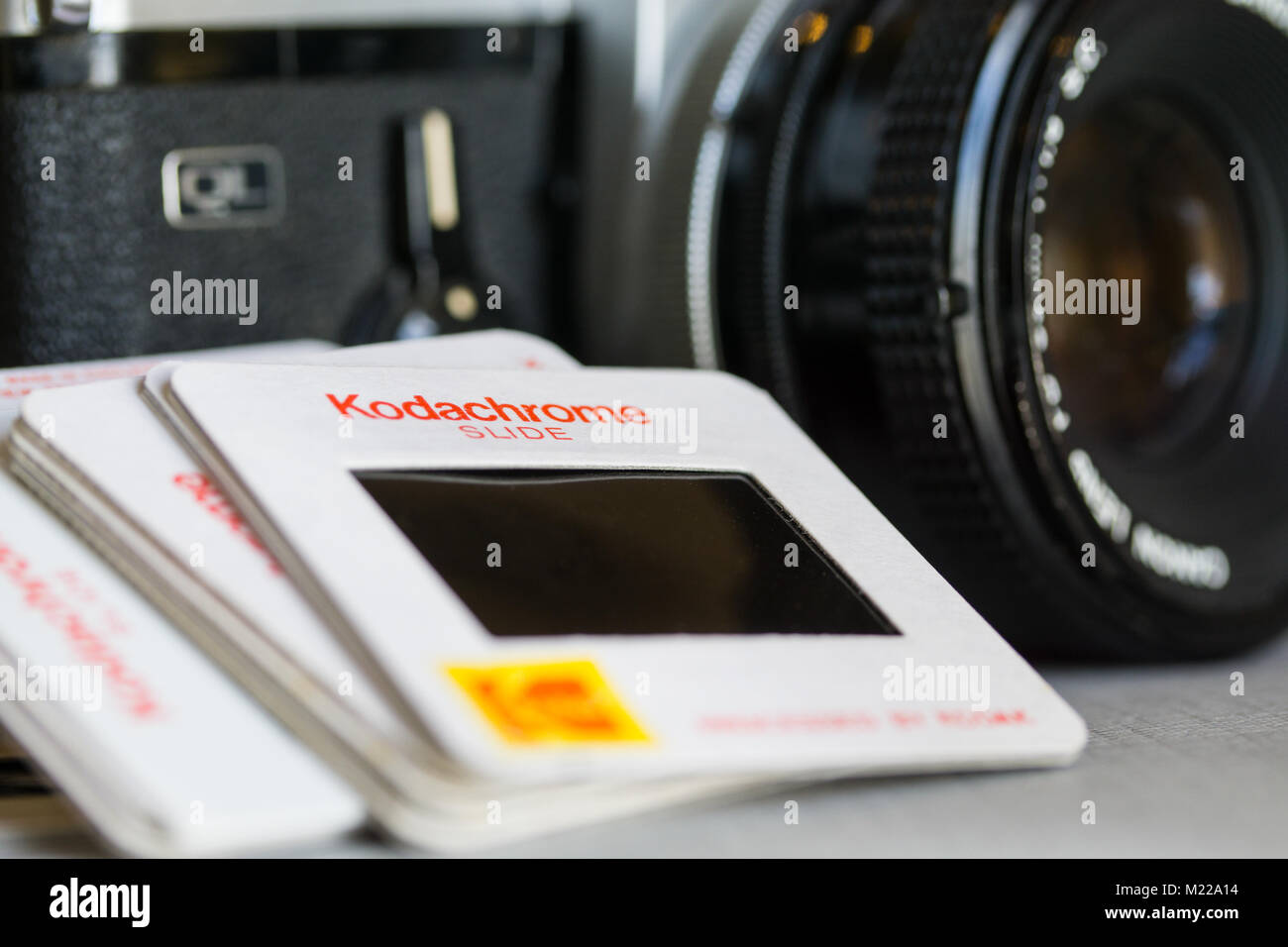 Nahaufnahme der Kodachrome-Diaobjektive neben einem Vintage-Kameraobjektiv, die analoge Fotografie, Filmkultur und die Attraktivität klassischer Medien hervorheben. Stockfoto
