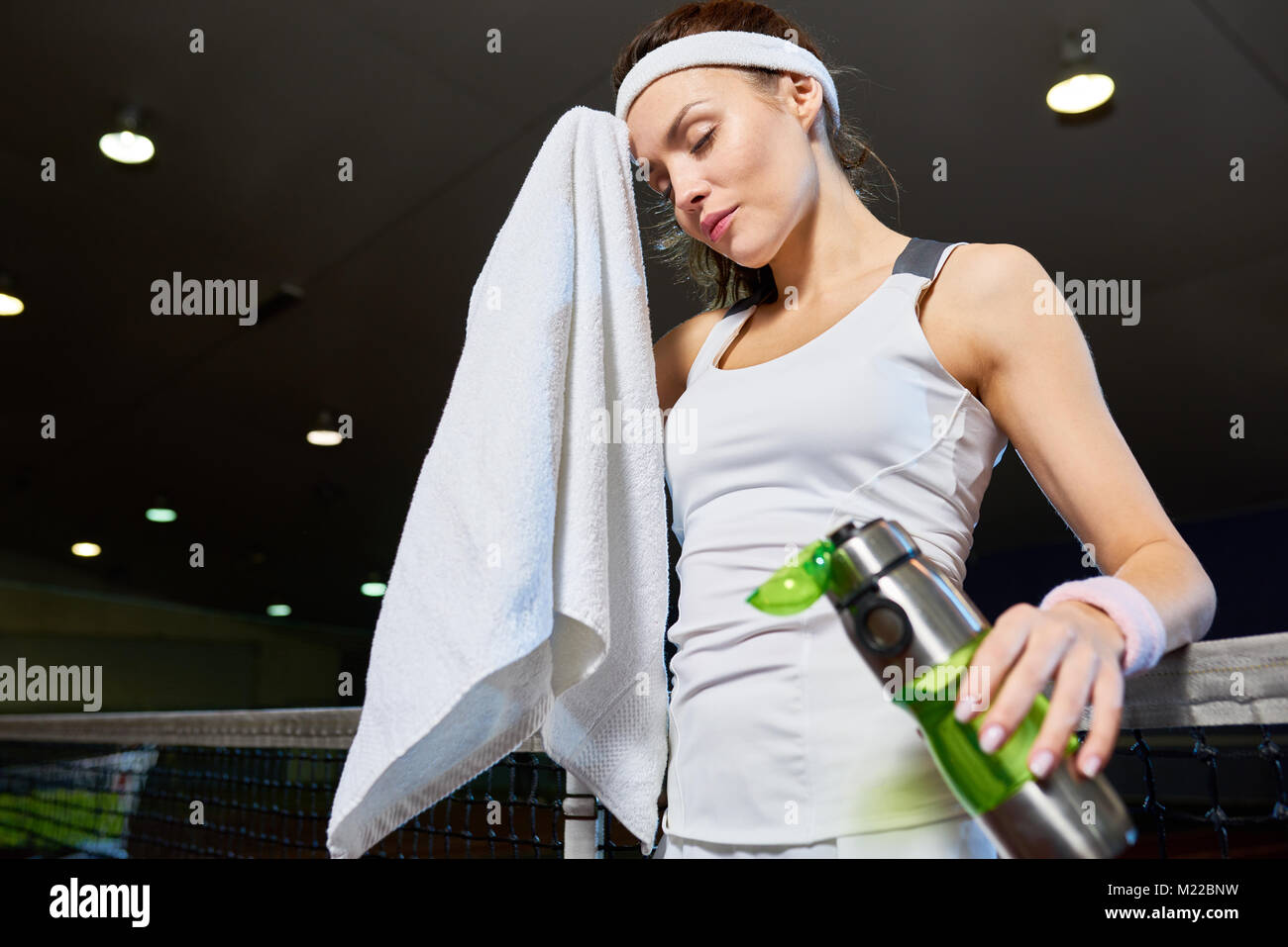 Taille bis Portrait von weiblichen tennis player abwischen Stirn mit Handtuch unter Bruch von Praxis in der Tennishalle, kopieren Raum Stockfoto
