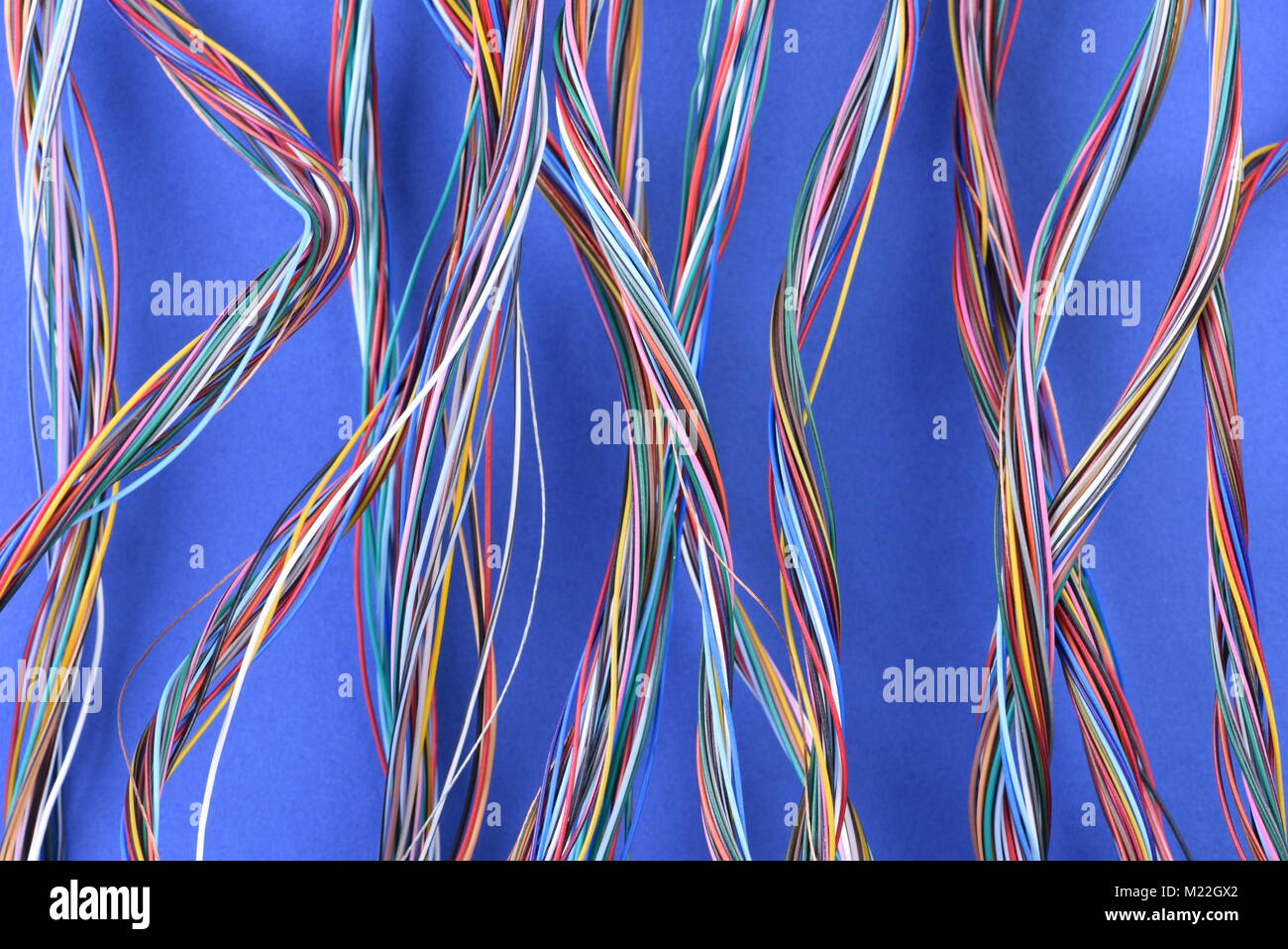 Strudel der bunten elektrischen Leitungen auf blauem Hintergrund Stockfoto