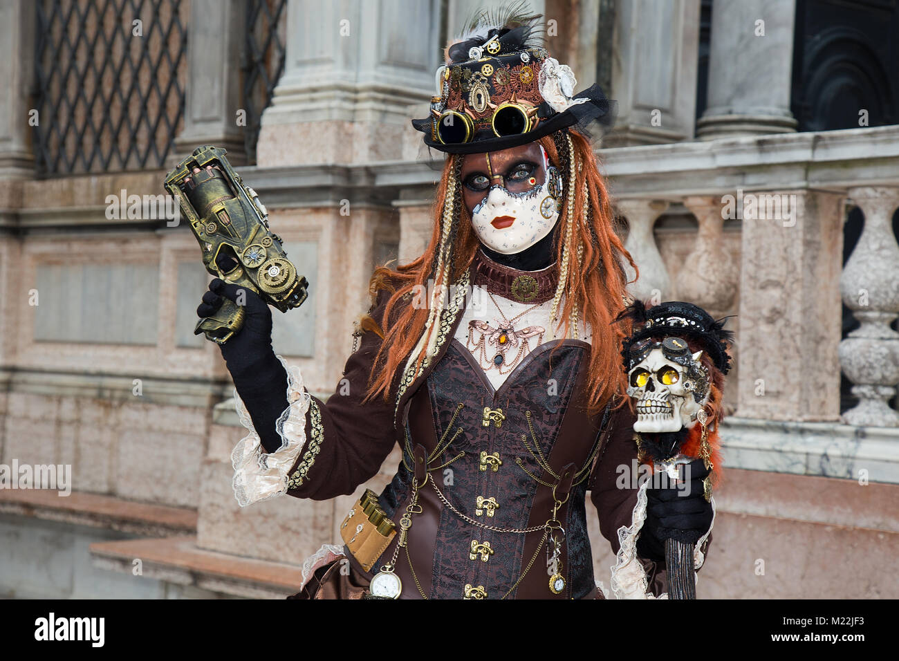 Weibliche Venezianische Maske mit Gewehr auf den Markusplatz in Venedig - Karneval in Venedig Stockfoto