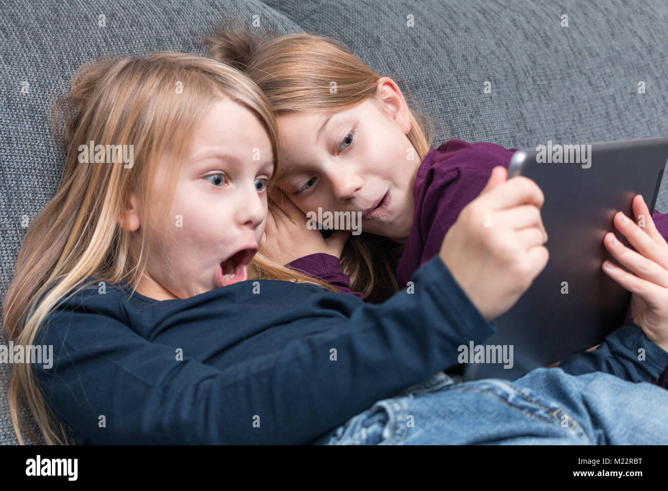 2 Mädchen sind begeistert von unterhaltsamen Inhalten mit dem Tablet Stockfoto