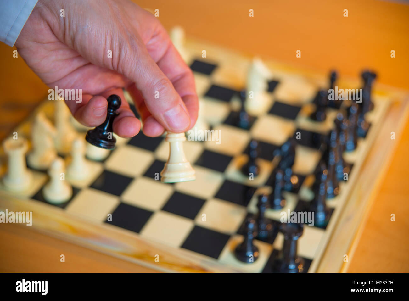 Schach: des Menschen Hand mit schwarzen und weißen Bauern. Stockfoto