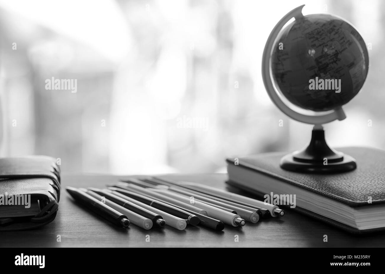 Ein Stift auf dem Schreibtisch mit kleinen Globus Stockfoto