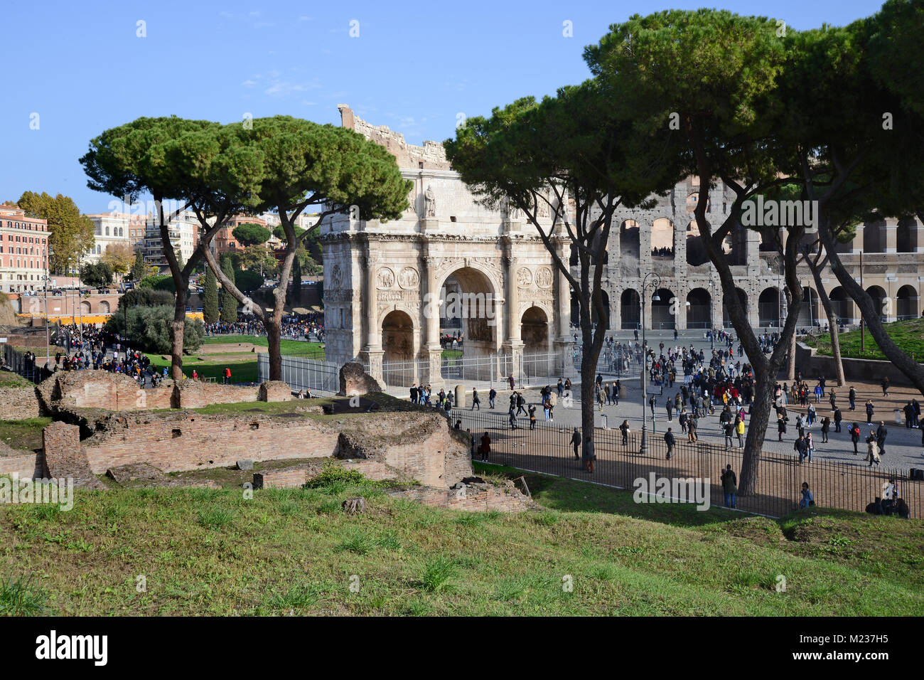 Der Torbogen von Konstantin mit dem Colosseum hinter mit Massen von Touristen, aus dem unteren Teil des Palatin in Rom Stockfoto