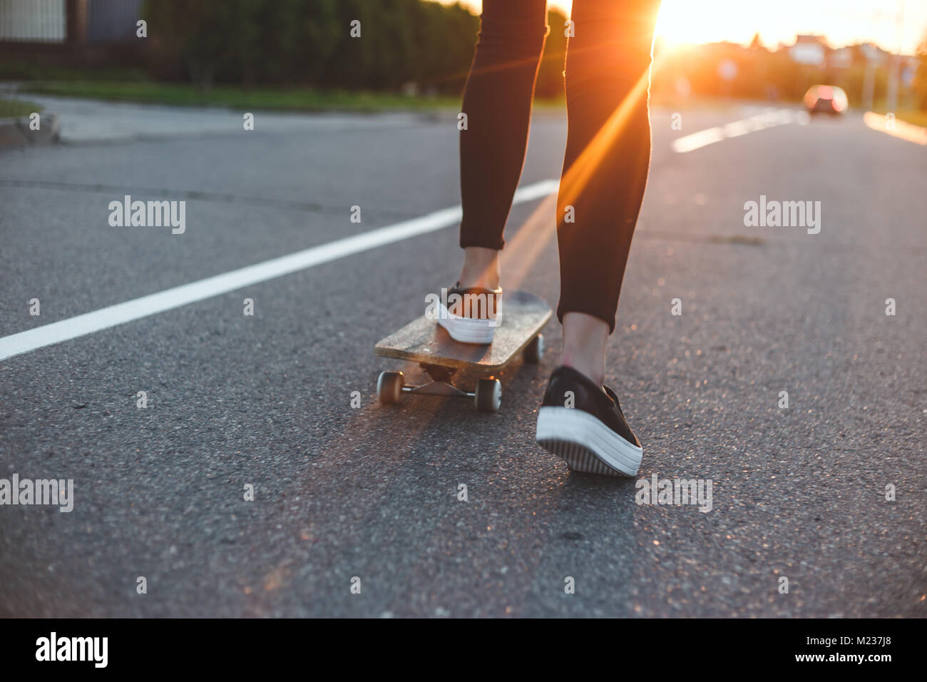 Junge skateboarder Beine reiten auf Skateboard vor der Sonne Stockfoto