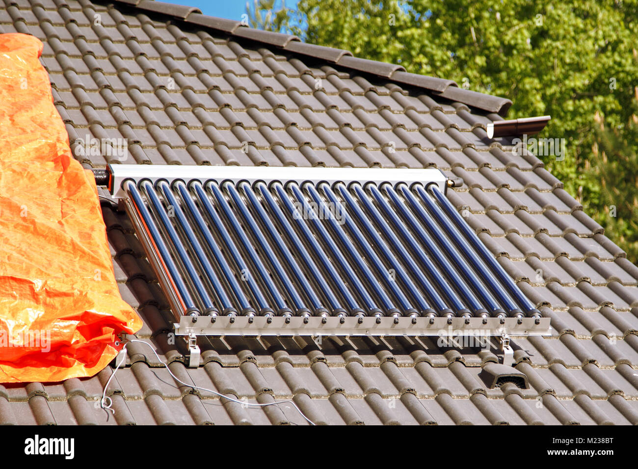 Solar Glas Rohr Warmwasser panel Array auf ein Haus Dach vor einem blauen  Himmel montiert Stockfotografie - Alamy