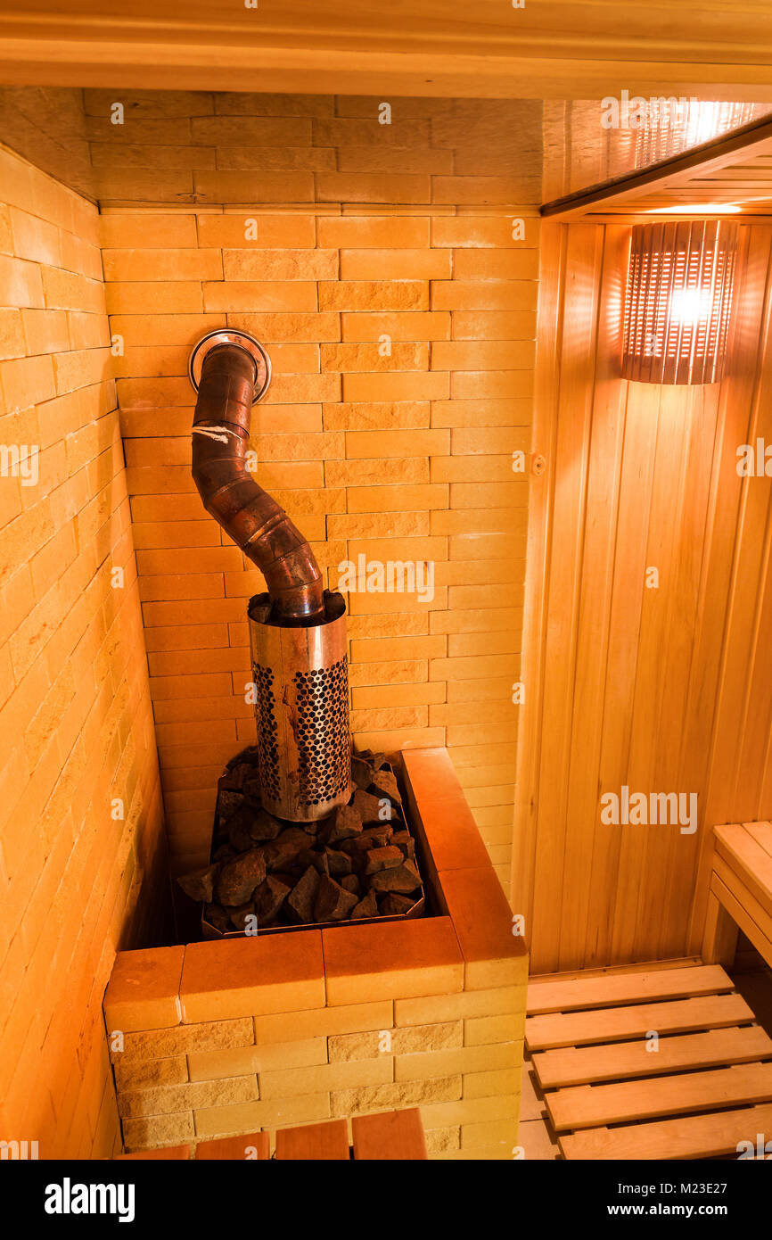 Technologie, Inneres, spa-Konzept. Auf der Ecke des Zimmer von Dampfbad, die mit Holz und schönen mit weichem Licht beleuchtet eingerichtet ist, gibt es Ofen Stockfoto
