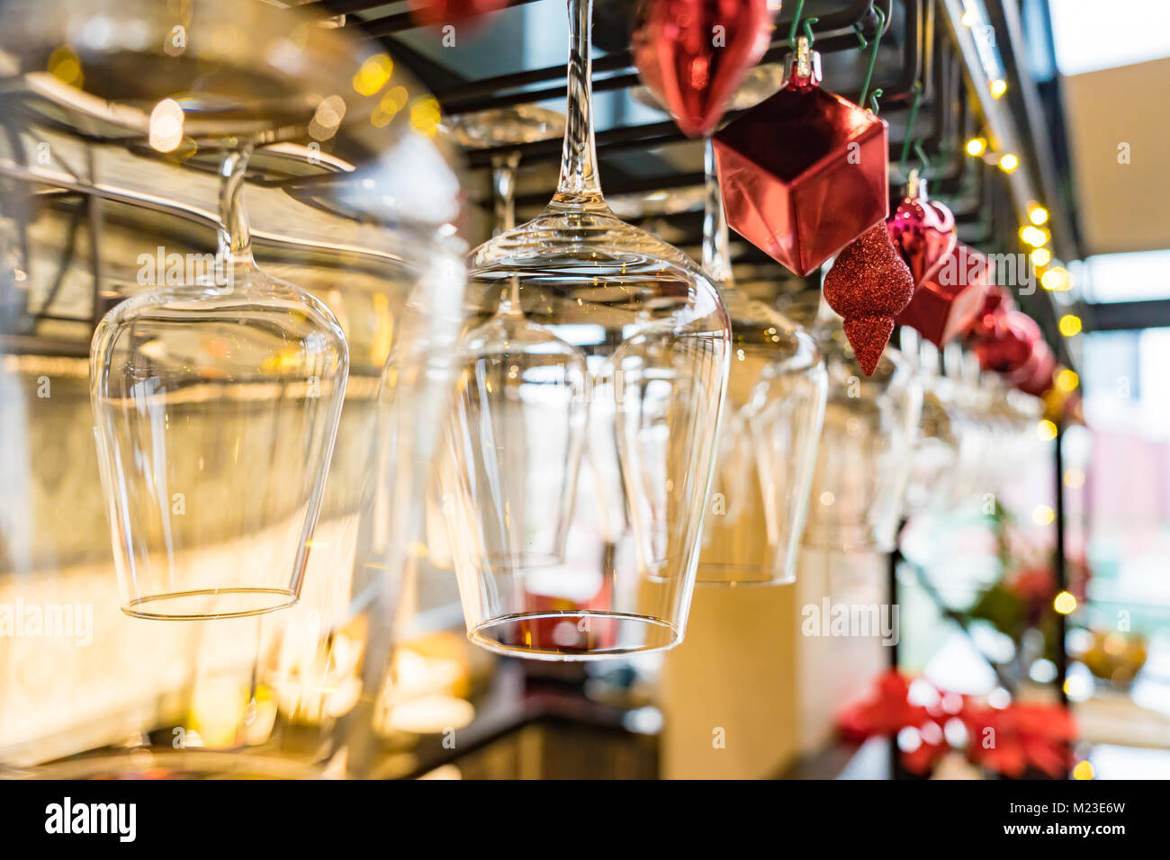 Leere Gläser Wein über einer Bar Rack auf dem Weihnachtsschmuck Hintergrund, selektiver Fokus Stockfoto