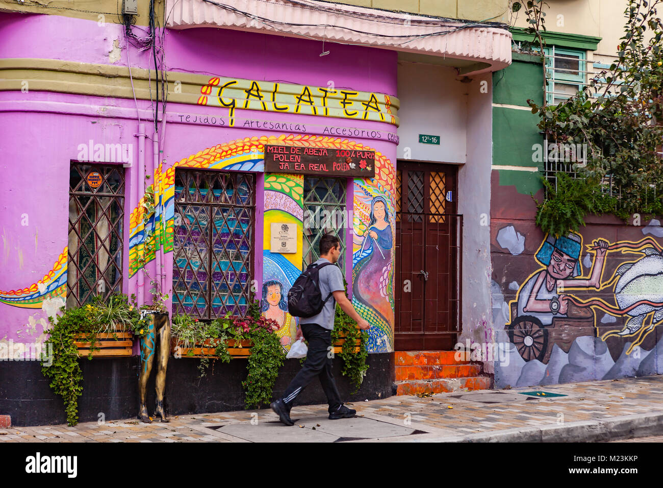 Bogota, Kolumbien - 28. Mai 2017: Eine lokale kolumbianischen Mann vorbei an einigen hell gestrichenen Fassaden in La Candelaria Bezirk in der Hauptstadt Stockfoto
