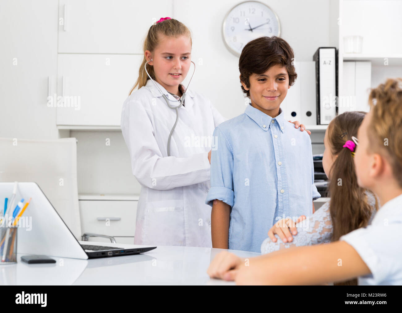 Junge weibliche Arzt in Uniform führende medizinische Termin mit Kindern Stockfoto