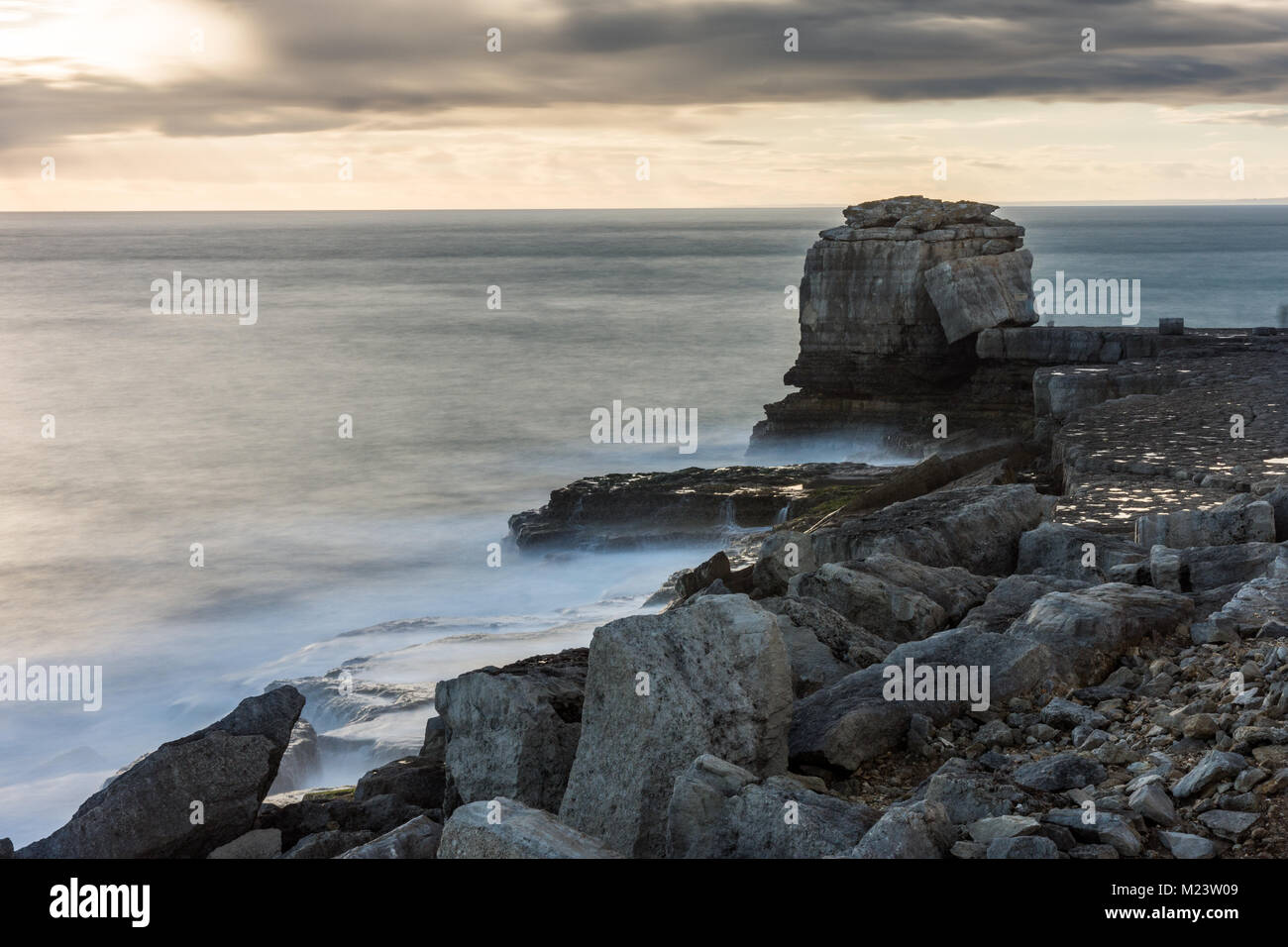 Die Sonne geht hinter Pulpit Rock, eine von Kalkstein auf die stark abgebaut, Küste von Portland Bill in Dorset auf Englands Jurassic Coast stack. Stockfoto