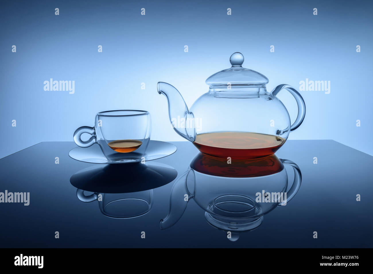 Studio Bild aus transparentem Glas Schale und Teekanne mit geringen Menge golden braun schwarz Tee an die Böden der Teekanne und Schale. Stellen Sie sich Stockfoto