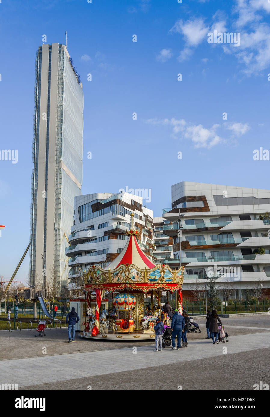 Kinder spielen auf einem Merry-go-round up im Tre Torri Citylife Viertel von Mailand, Italien, der an einem sonnigen Wintertag einstellen Stockfoto