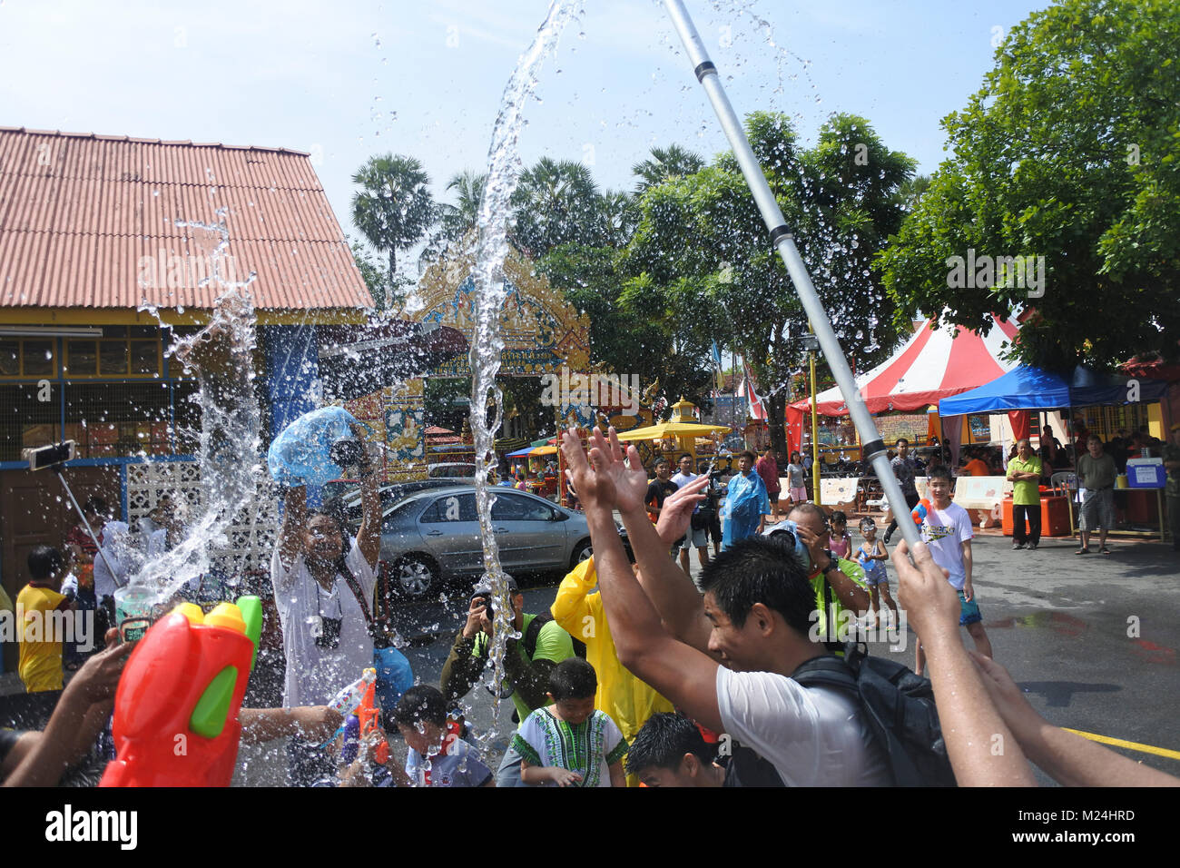 Die Leute an der Songkran Festival werfen Wasser in Eimern an einander von einem Alrge Tank mit Wasser, Wasser in Bewegung ist eingefroren Stockfoto