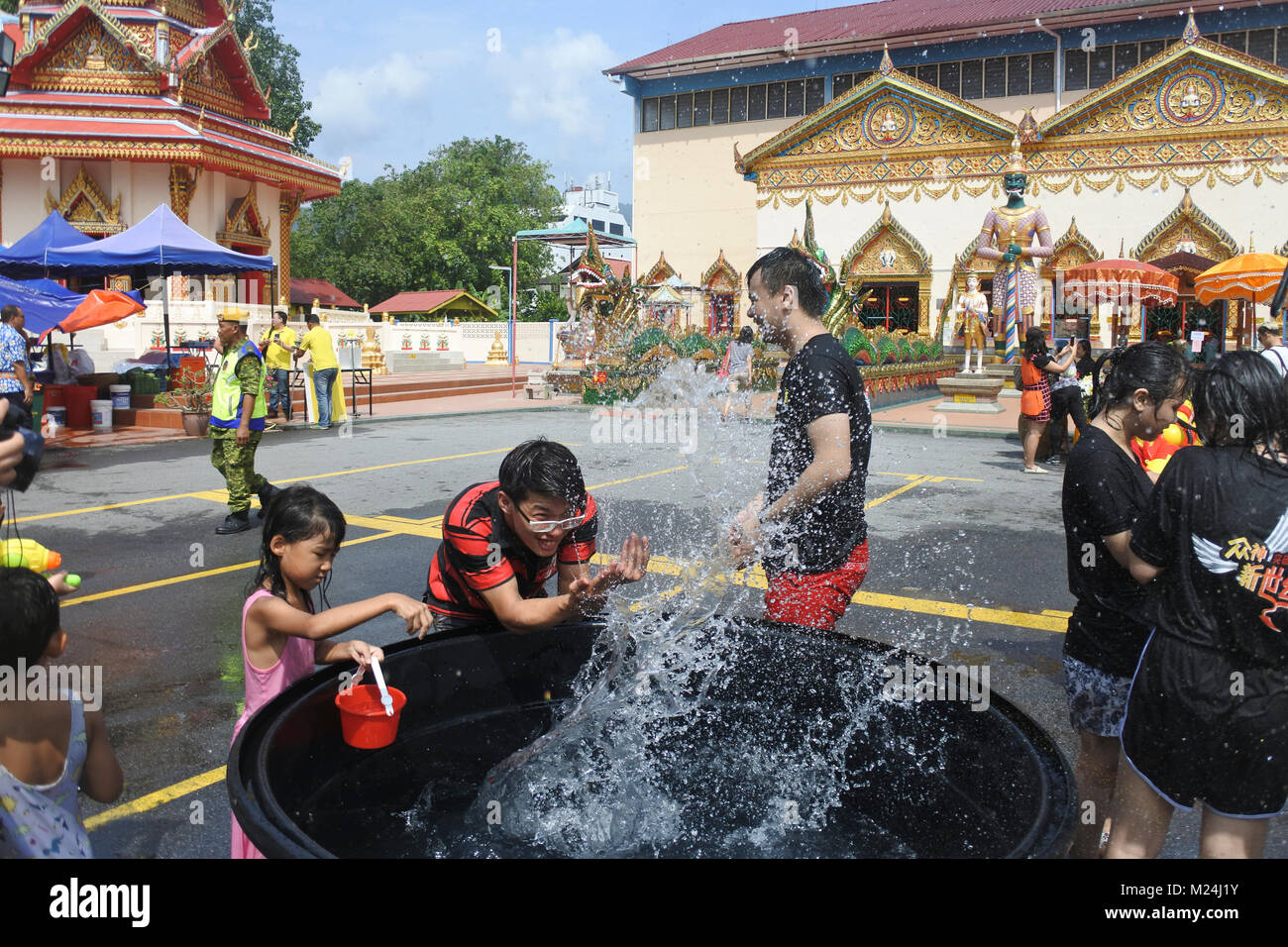 Die Leute an der Songkran Festival werfen Wasser in Eimern an einander von einem Alrge Tank mit Wasser, Wasser in Bewegung 0 eingefroren Stockfoto