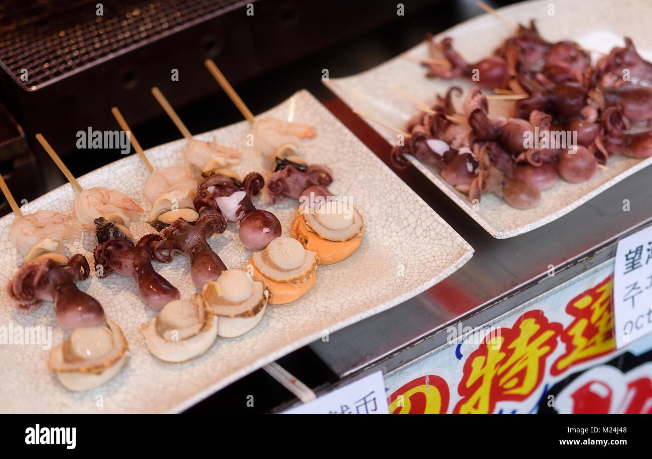 Japanische Street Food, seafood Spieße, gegrillte Jakobsmuscheln Takotamago Hotateyaki, baby Tintenfisch und Garnelen auf einem Stock in Kyoto, Japan Stockfoto