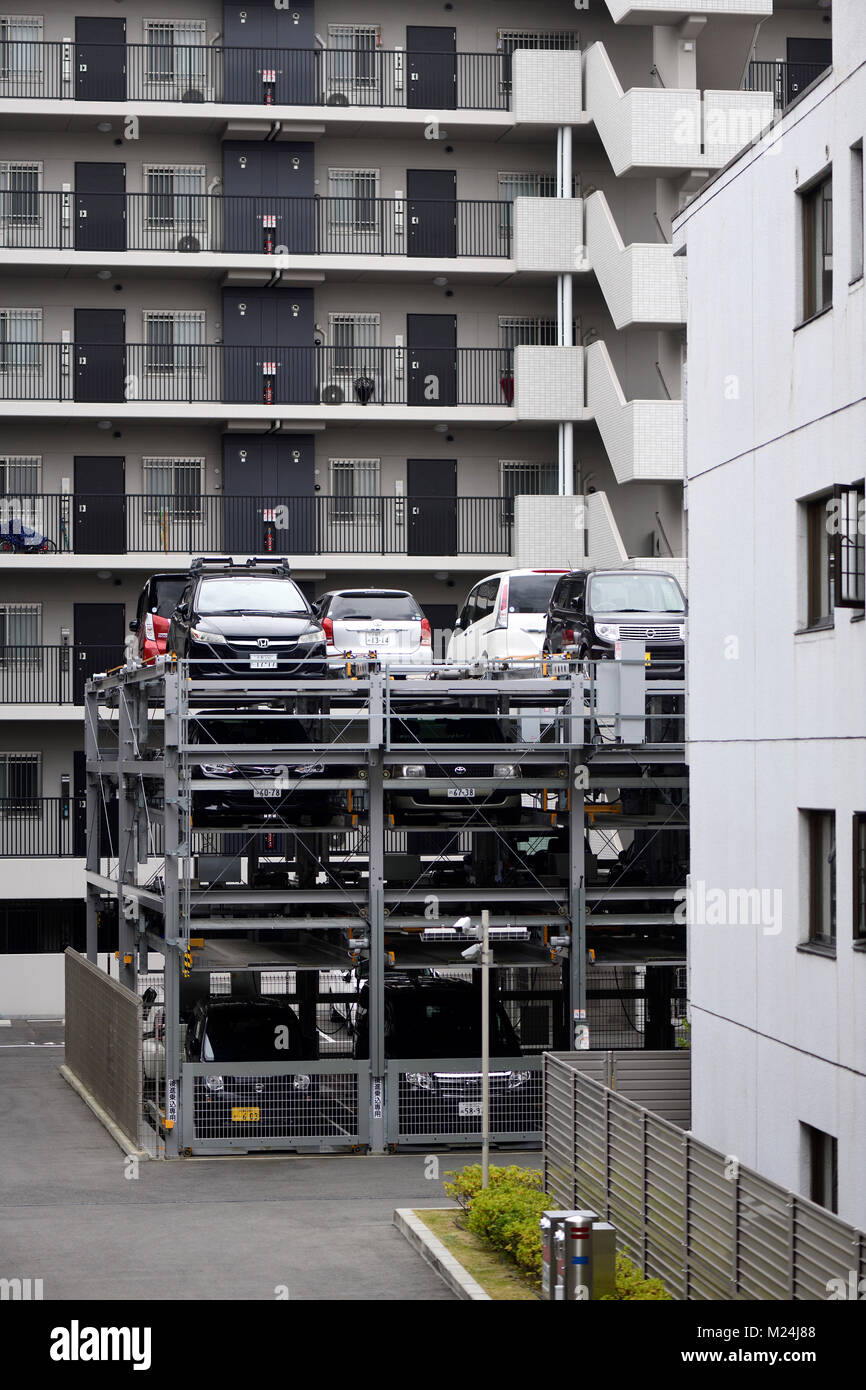 Autos, die in einem mehrstufigen vertikalen 3-stöckigen automatisierte Parkplatz mit einem Aufzug durch ein Mehrfamilienhaus in Kyoto, Japan 2017 geparkt Stockfoto