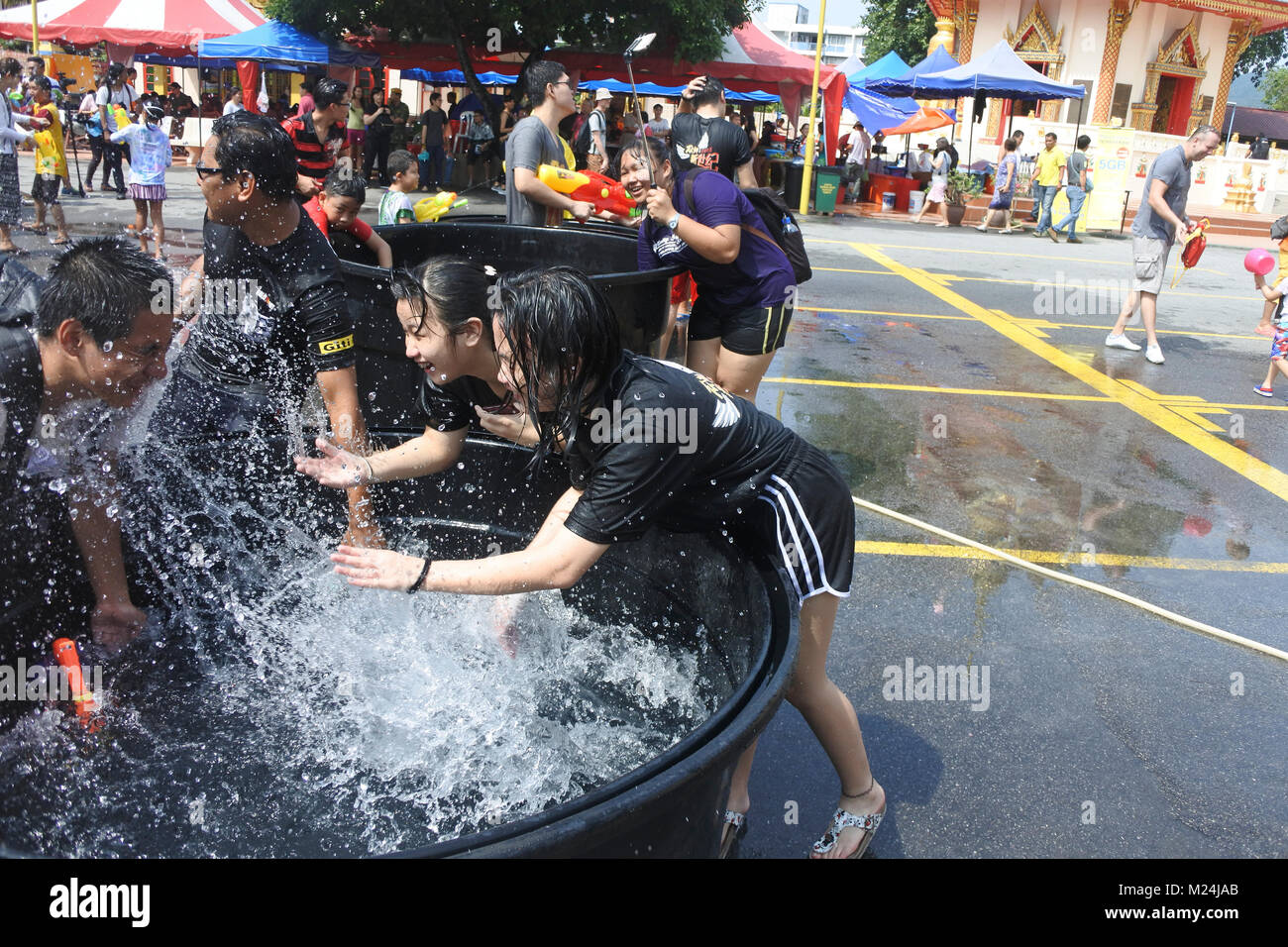 Zwei Mädchen Spritzen ein Mann am Songkran Wasser festical in Penang Stockfoto