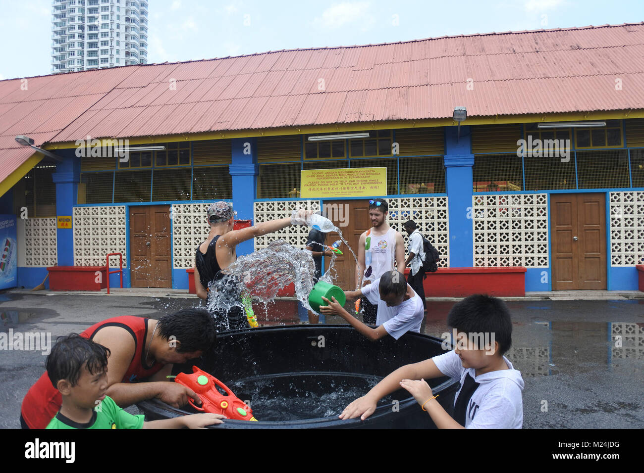 Die Leute an der Songkran Festival werfen Wasser in Eimern an einander von einem Alrge Tank mit Wasser, Wasser in Bewegung ist eingefroren Stockfoto