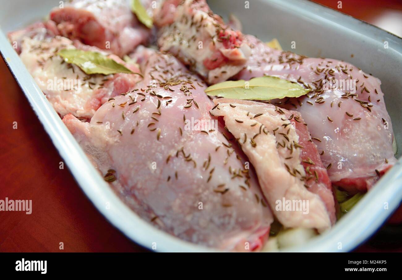 Stücke mit einem Ungekochten erfahrener Hase und Schwein Fleisch in einen Bräter. Stockfoto
