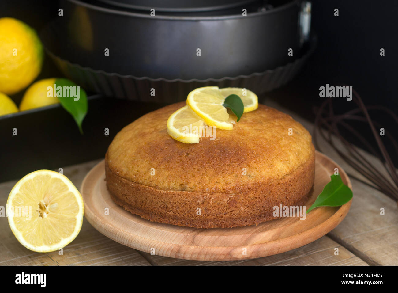 Zitronenkuchen und Zitronen auf einem dunklen Hintergrund. Stockfoto