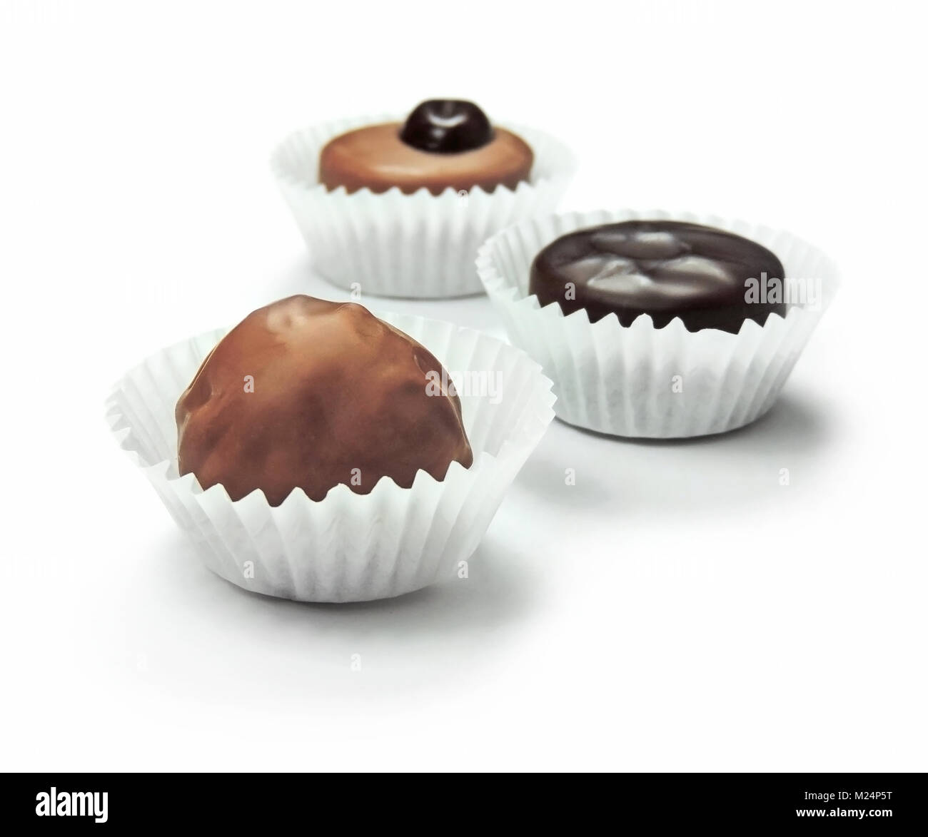 Leckere Schokolade Bonbons oder Schokolade Trüffel mit Papier, auf weißem Hintergrund. Stockfoto
