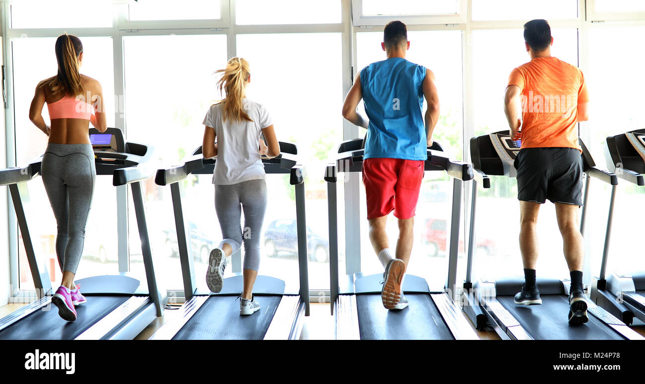 Bild von Menschen, die auf Laufband im Fitnessstudio Stockfoto