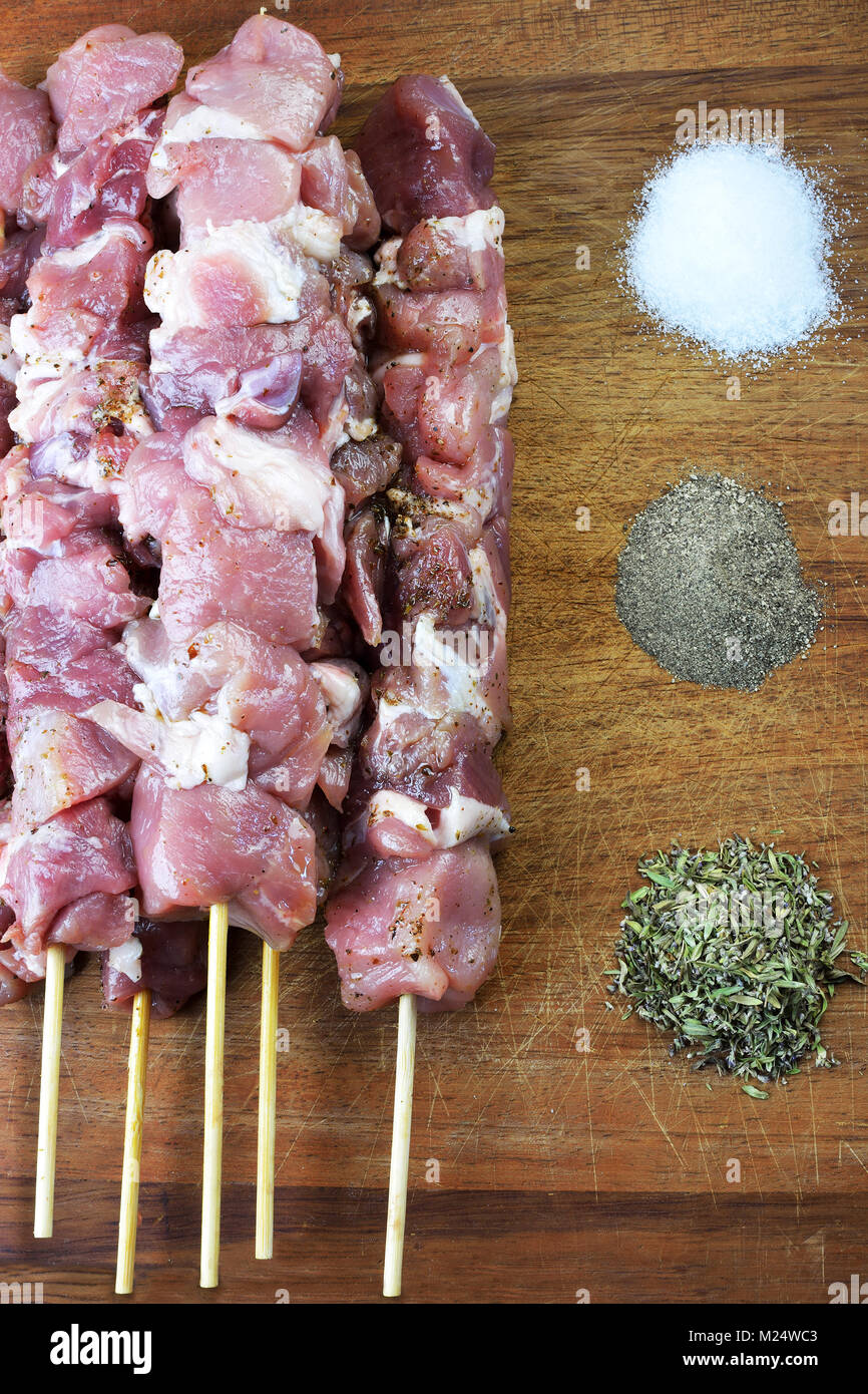 Raw souvlaki mit Gewürzen auf einem Holzbrett Stockfoto