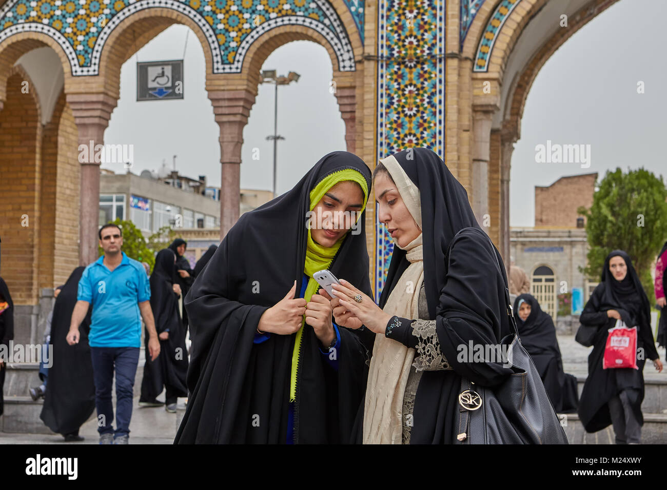 Teheran, Iran - 27. April 2017: zwei iranische Frauen in hijabs stehen und schauen Sie sich Fotos auf dem Smartphone in der Nähe der Shah Abdol Azim Schrein. Stockfoto