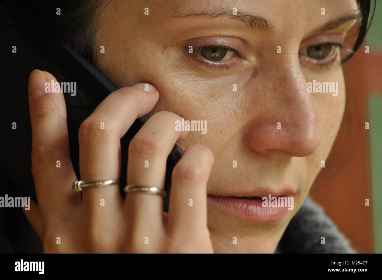 Die Frau unterhalten und nachdenklich. Mädchen mit Ohrringe. Lächeln und Zufriedenheit. Stockfoto