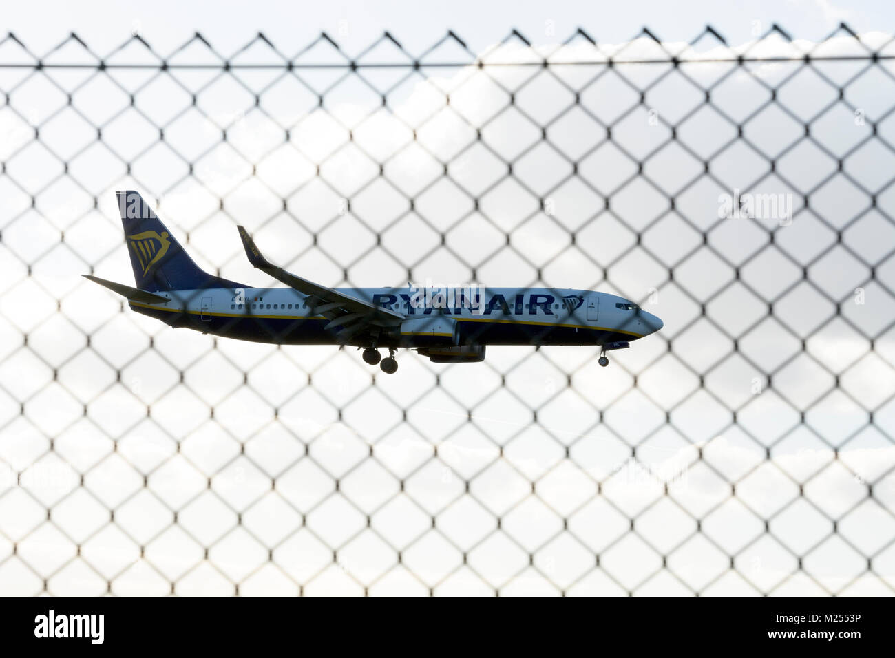 Ryanair Boeing 737 Landung am Flughafen Birmingham, durch Kettenglied Sicherheit Fechten gesehen, Großbritannien Stockfoto