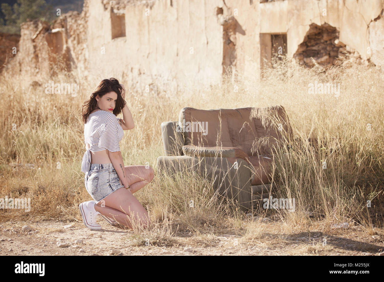 Schöne Mädchen tragen Denim Shorts und Top in der Landschaft Stockfoto