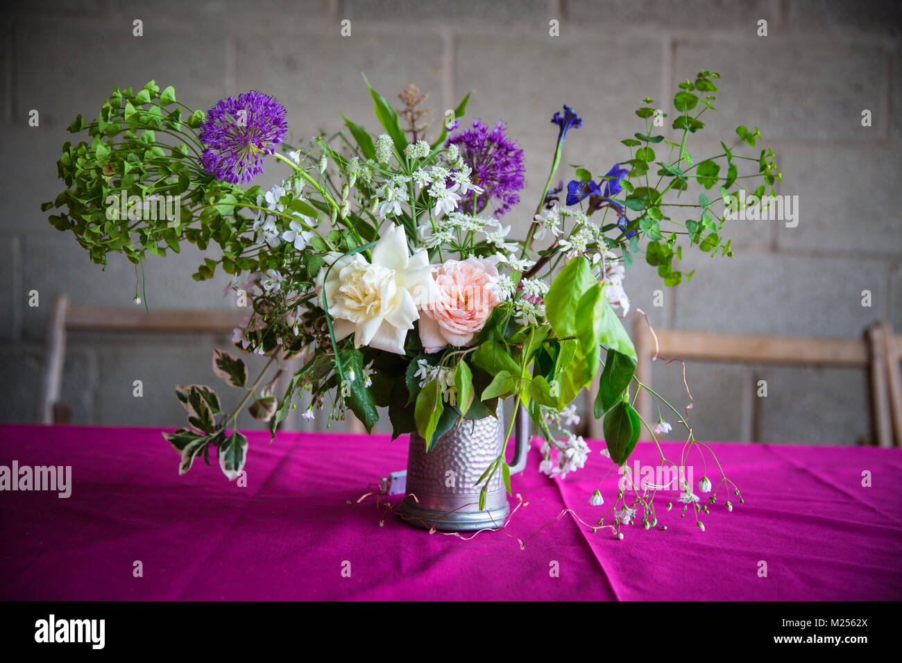 Hochzeitstisch Blumenschmuck auf rosa Tischdecke Stockfoto