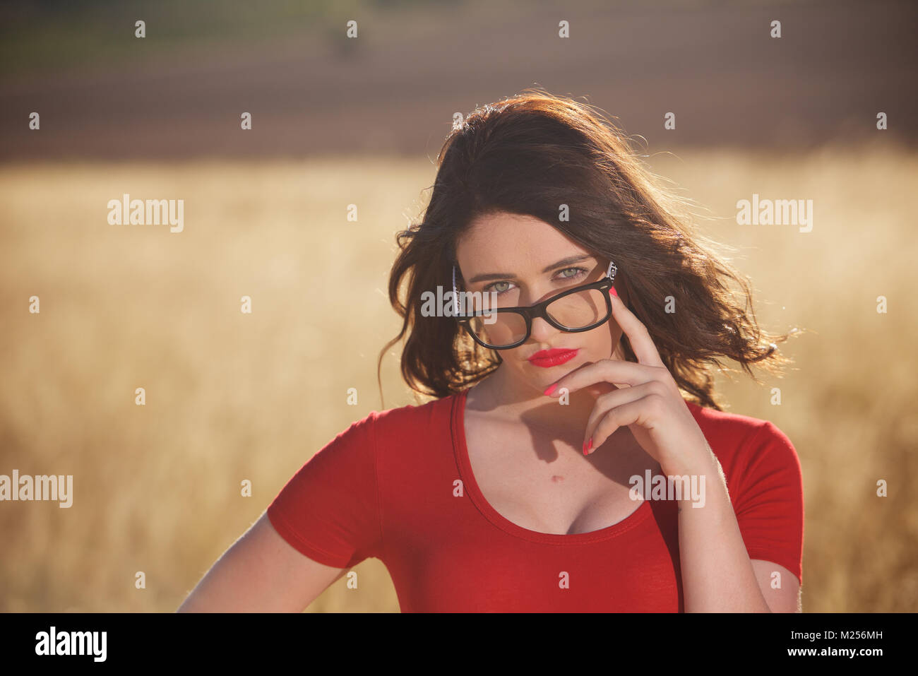 Schöne brünette Mädchen - Kopf und Schultern mit Brille und auf dem Land. Stockfoto