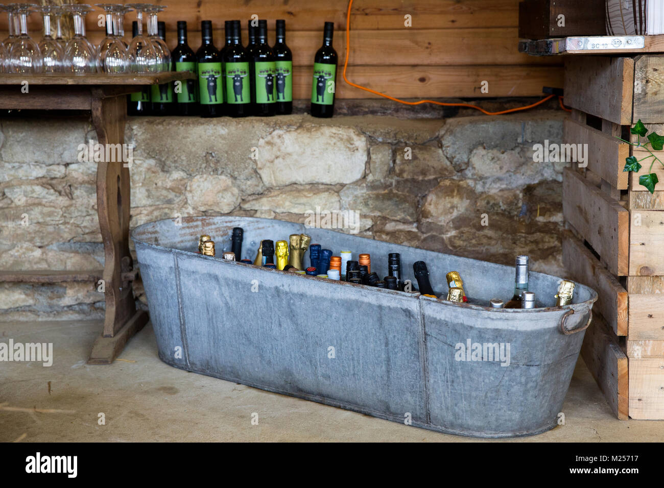Scheune mit Zinnbad voller Flasche trinken, Bierflaschen und hölzernen Tisch mit Gläsern Stockfoto