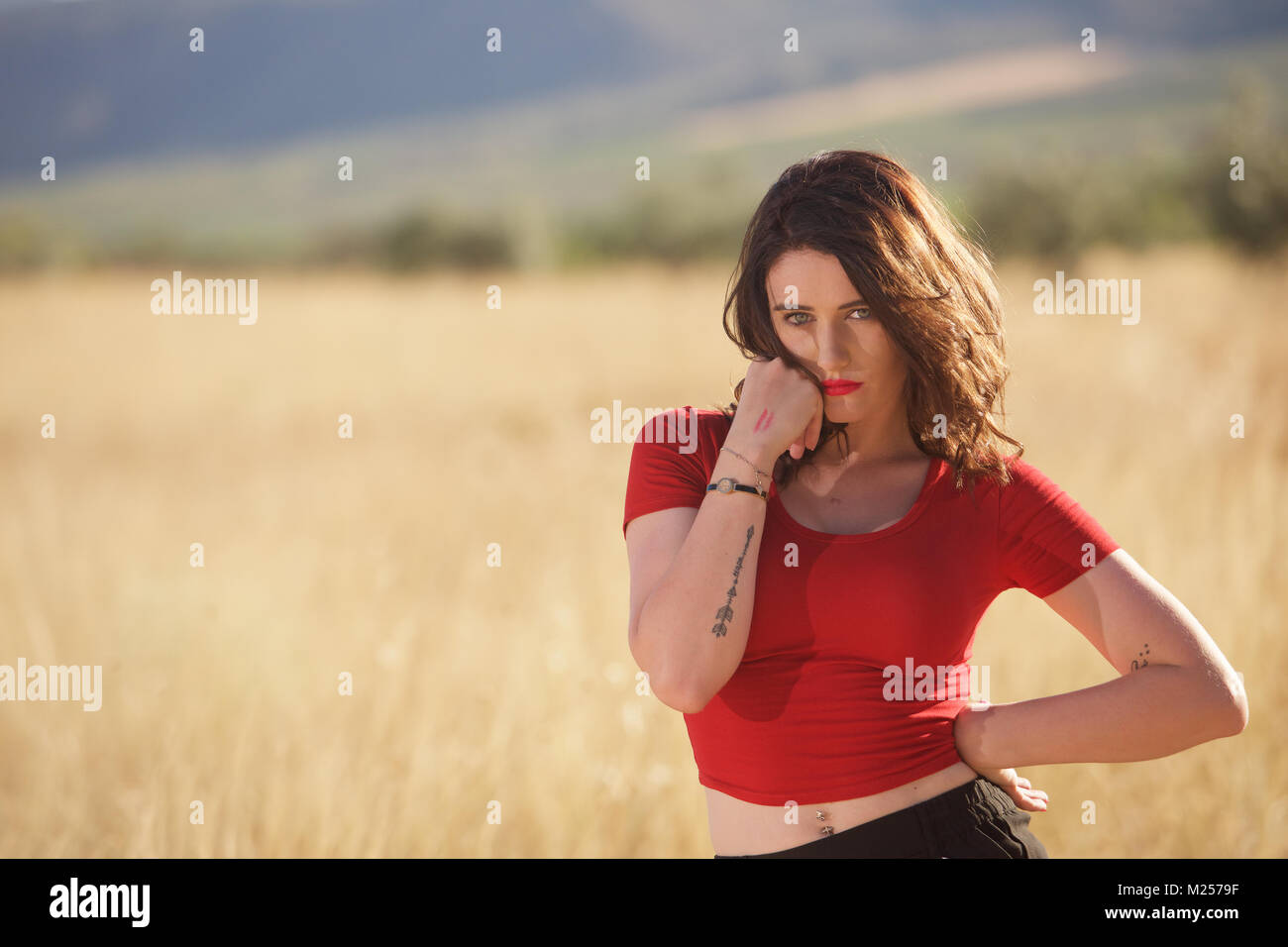 Schöne brünette Mädchen in schwarzen Shorts und ein rotes T-Shirt auf dem Land Stockfoto