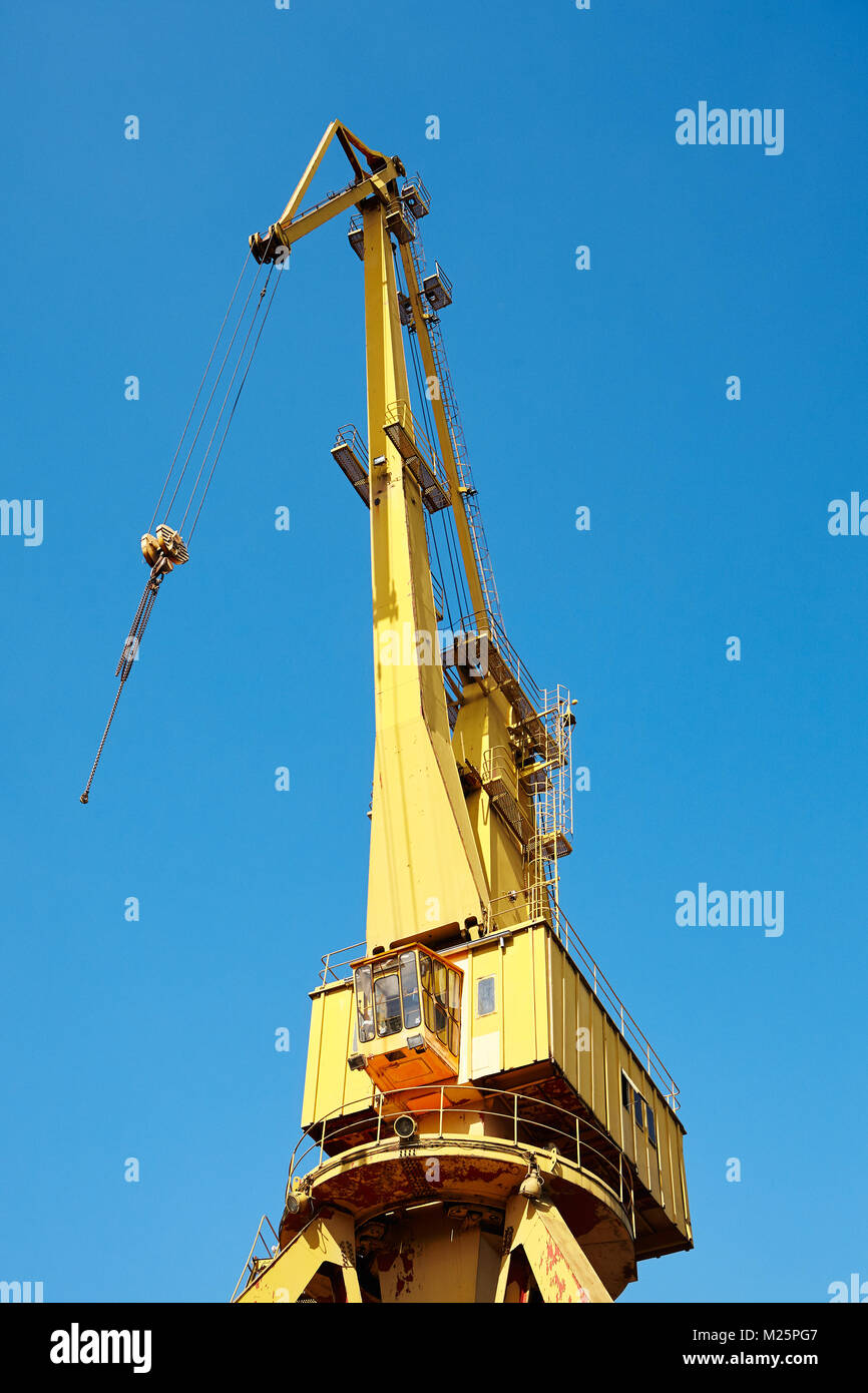 Gelber Kran in einer Werft gegen den blauen Himmel. Stockfoto