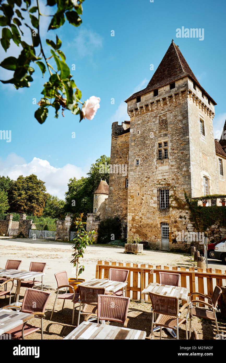 Cafe Tabellen und das Chateau de la Marthonie in St Jean de Cole in der Dordogne Frankreich - eines der schönsten Dörfer von Frankreich Stockfoto