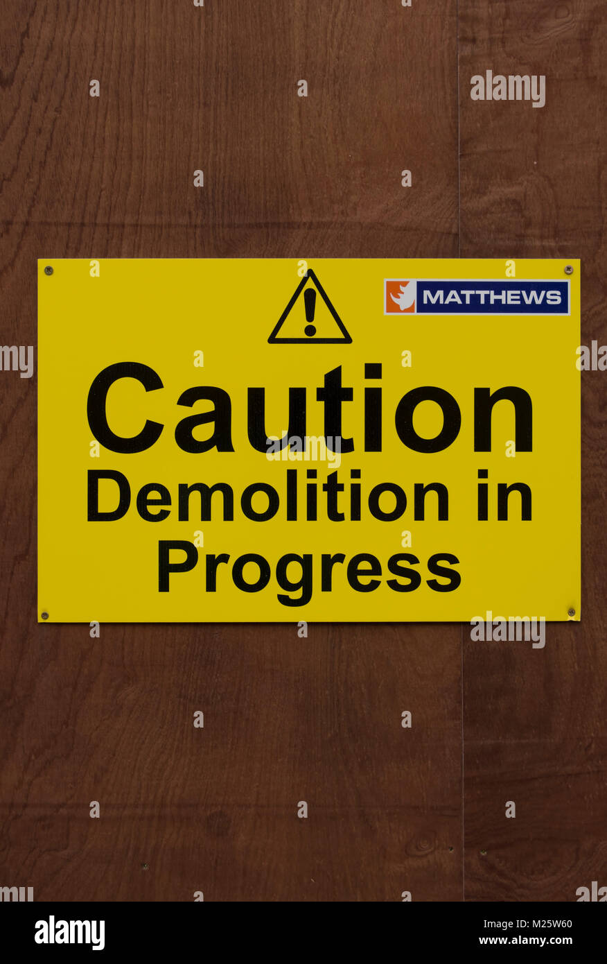 Vorsicht Abriss im Gange Warnschild, mit Ausrufezeichen und Logo der Demolition Company matthews Stockfoto