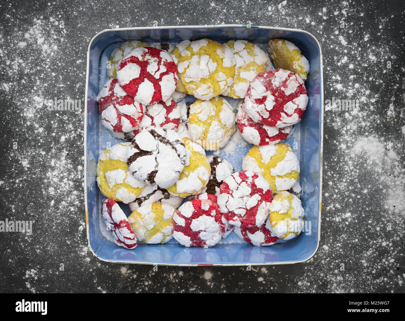 Hausgemachte Zitrone, Himbeere und Schokolade Crinkle Cookies in einer Dose auf schiefer Hintergrund Stockfoto