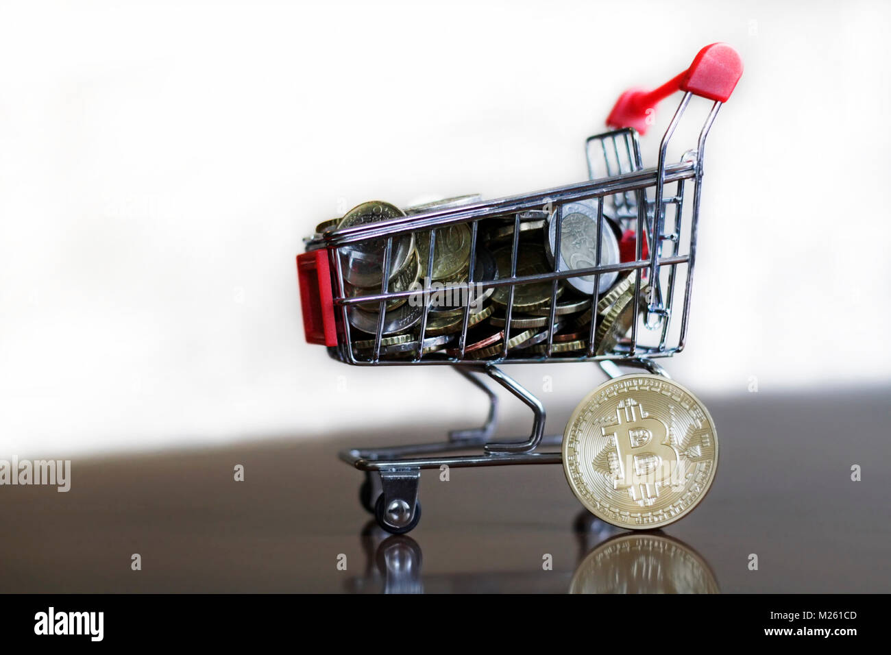 Trolley mit Münzen und Bitcoin Stockfoto