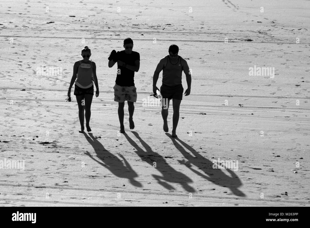 Silhouette von 3 Menschen zu Fuß auf einem Sandstrand, Cable Beach, Broome, West Kimberley, Western Australia Stockfoto