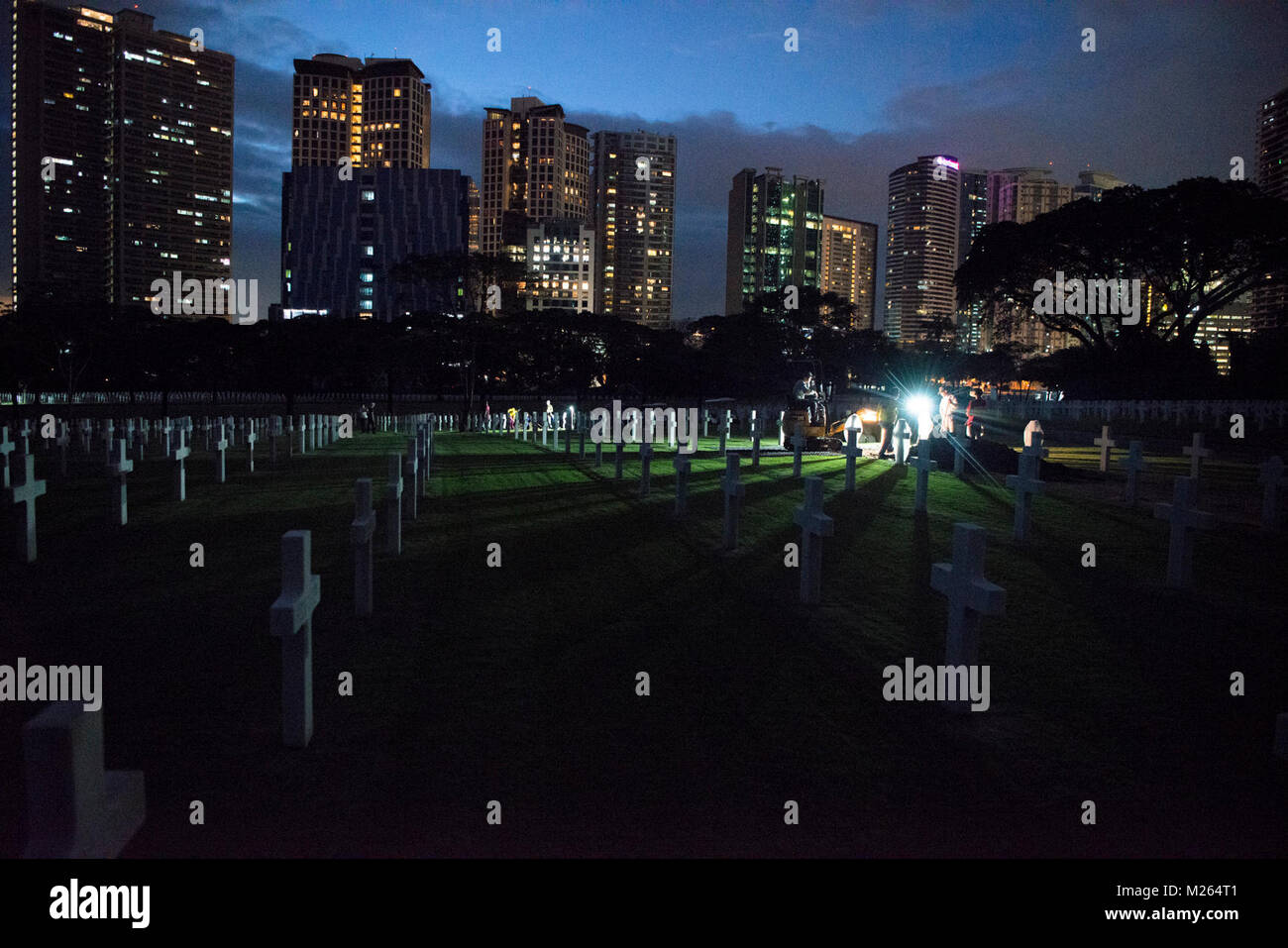 Die einheimischen Arbeiter mit der American Battle Monuments Kommission mit Mitgliedern der Verteidigung POW/MIA Accounting Agentur (DPAA) während einer disinterment im Manila American Cemetery in Manila, Philippinen, Jan. 22, 2018. Die DPAA disinterment war Teil der Anstrengungen, um die unbekannten während des Zweiten Weltkriegs verloren zu identifizieren und die möglichst vollständige Buchhaltung unserer fehlt Personal zu ihren Familien und der Nation. (U.S. Marine Corps Stockfoto