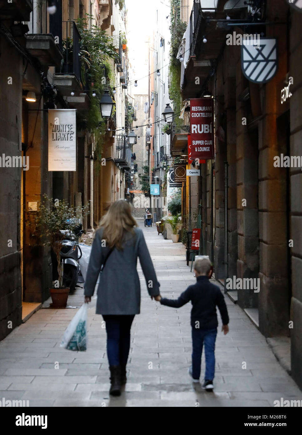 BARCELONA, SPANIEN: eine Mutter und Sohn halten Hände, während in einer engen Straße in der Nachbarschaft von Barcelona entfernt. (Foto von Matt Mai/Alamy) Stockfoto