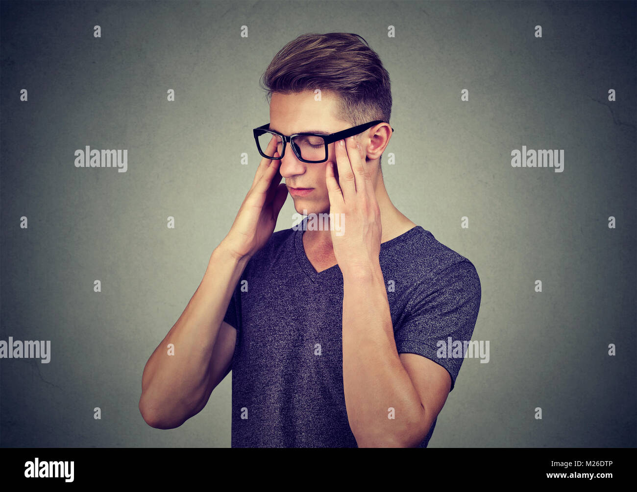 Junge legerer Mann in Brillen Tempel Reiben mit geschlossenen Augen versuchen, Informationen zu erinnern. Stockfoto